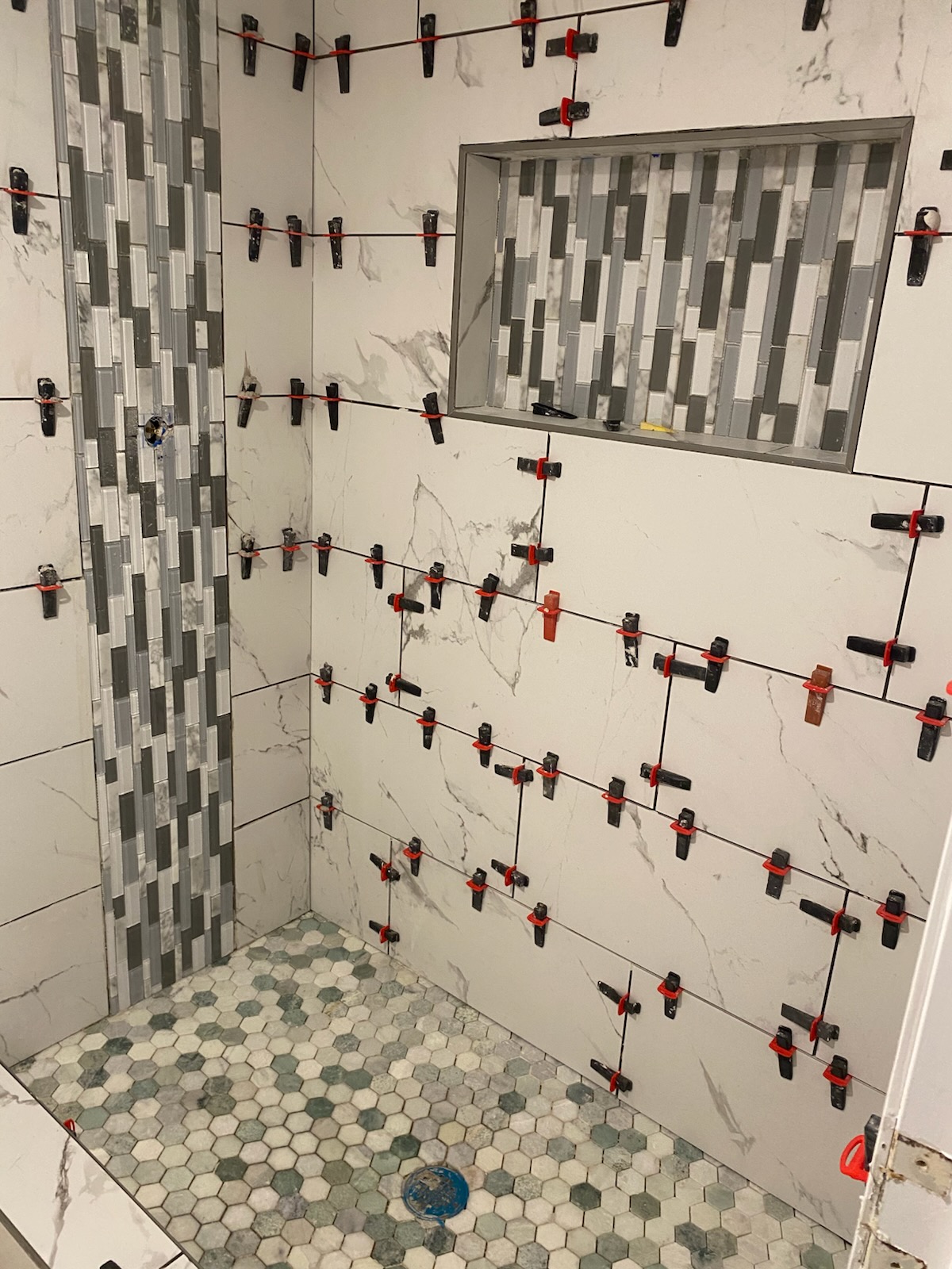 Shower tile with mosaic accent stripe and hex floor